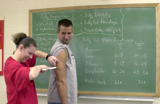 A student measuring body composition using skinfold testing